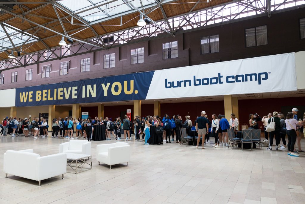 Burn Summit attendees gather beneath We Believe in You and Burn Boot Camp banners