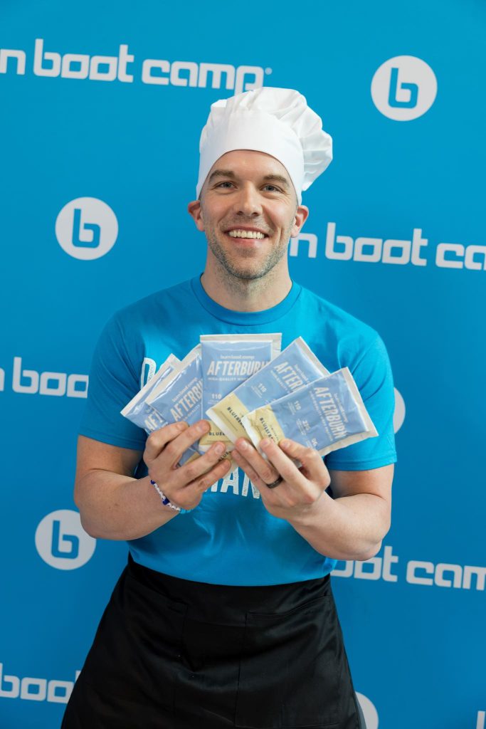 Matt Morris wears a chef hat and holds Blueberry Muffin Afterburn samples