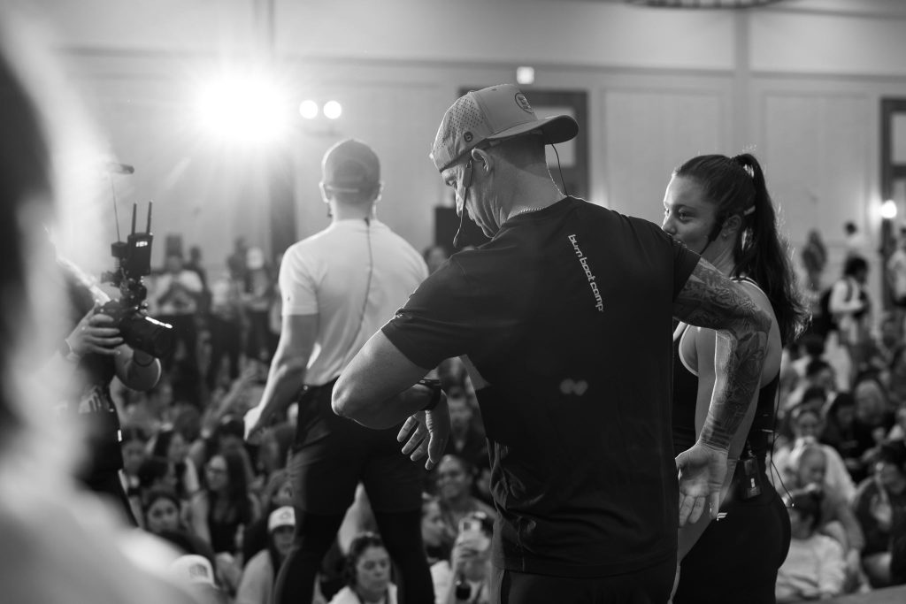 A Trainer coaches a participant during Camp in a black-and-white photograph