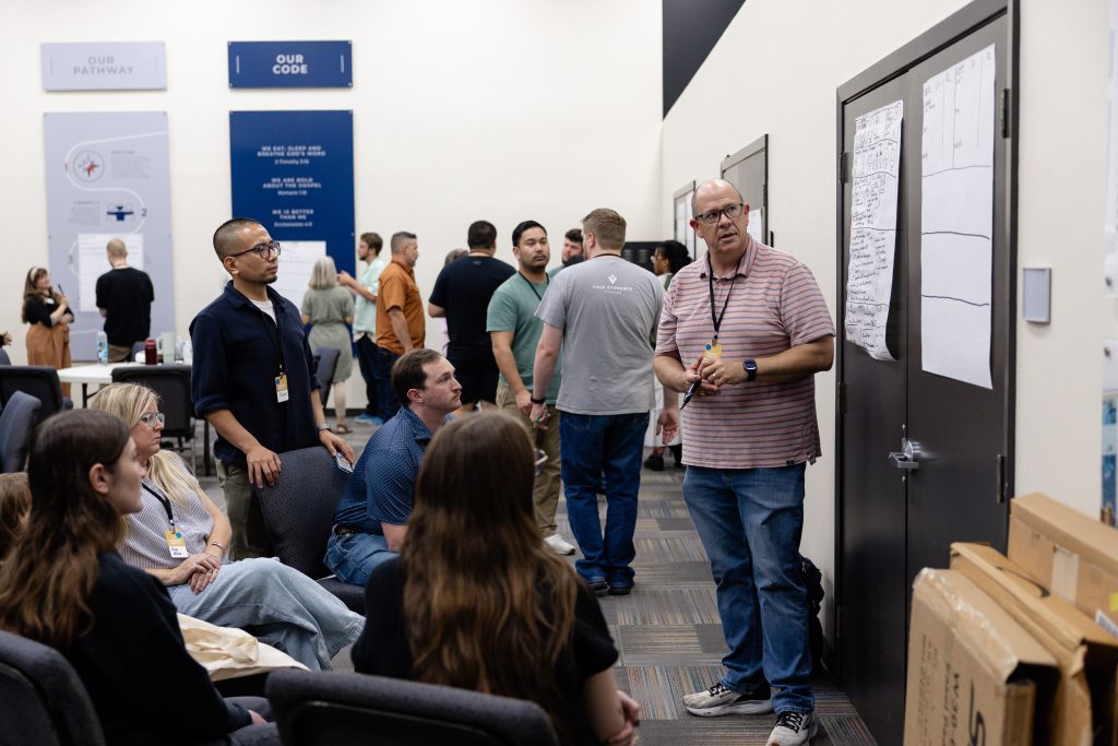 A facilitator discusses a group worksheet with collegiate ministry leaders.